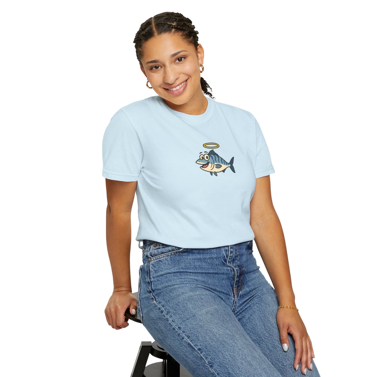 Person wearing a light blue t-shirt with a graphic design of a fish with a halo, sitting on a stool against a white background.