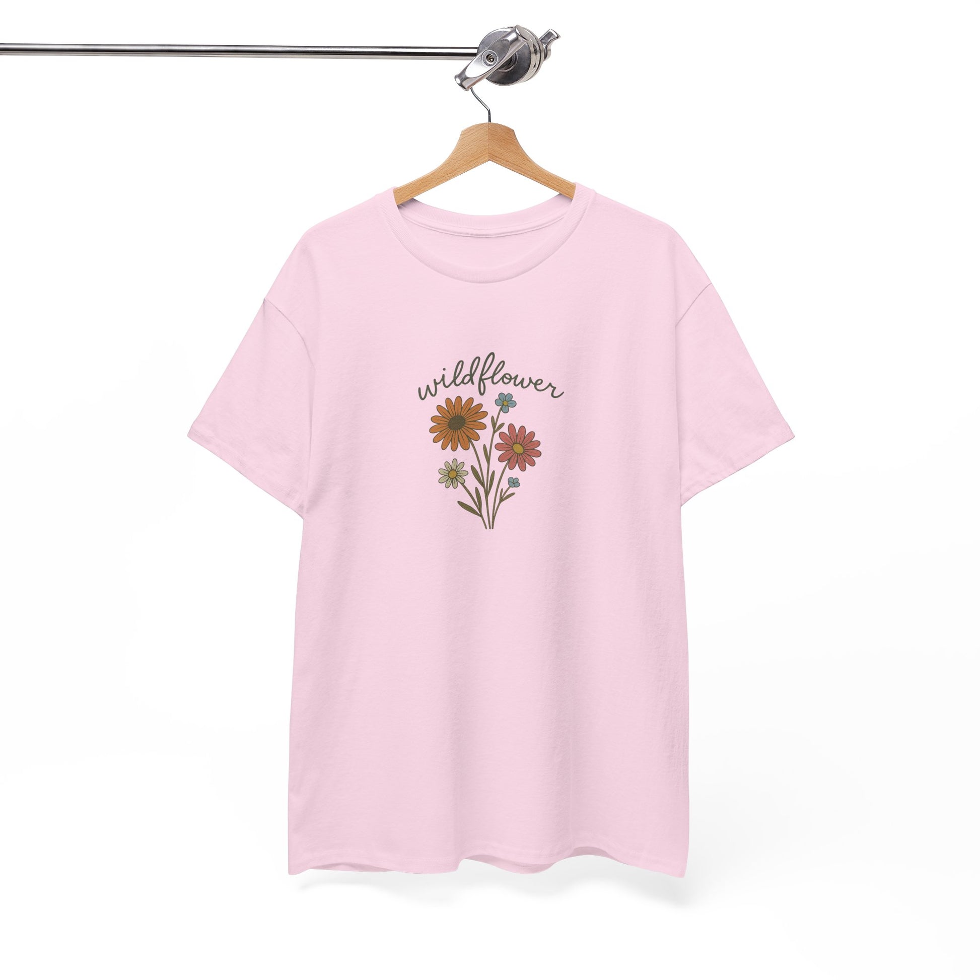 Pink t-shirt with floral design and 'wildflower' text on a hanger against a white background