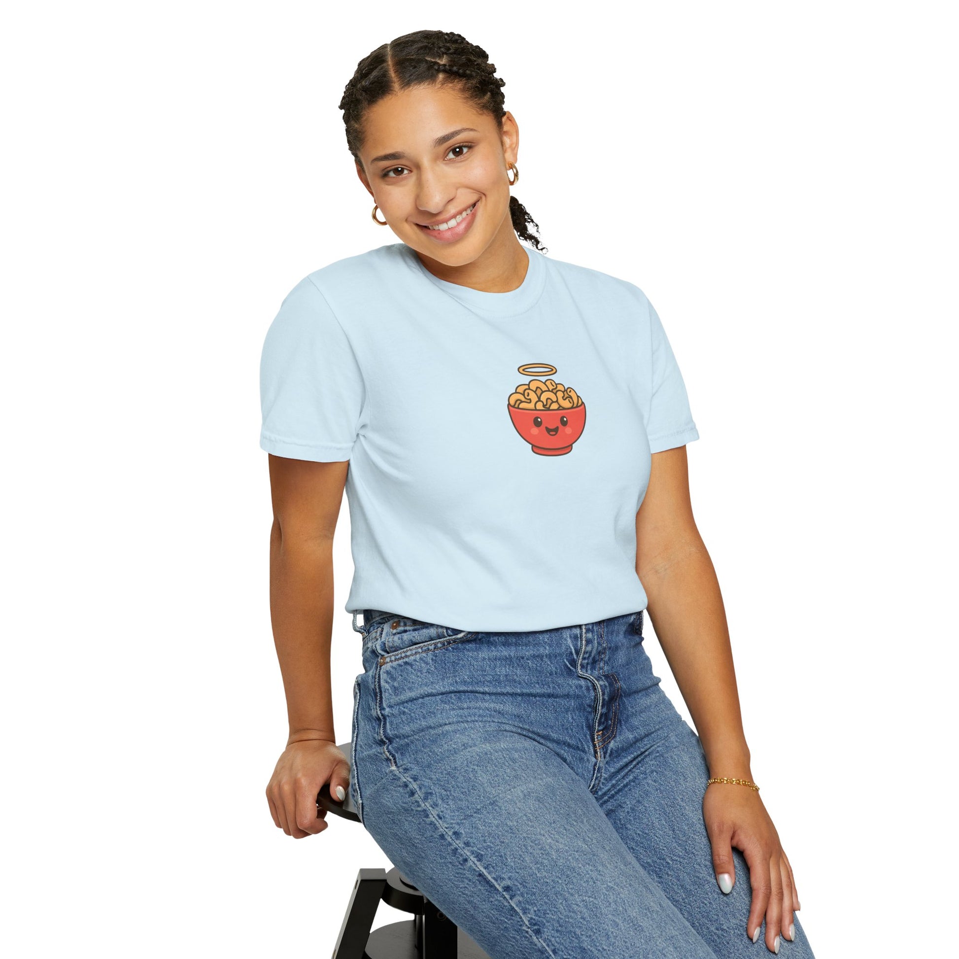 Person wearing a light blue t-shirt with a graphic design sitting on a stool against a white background
