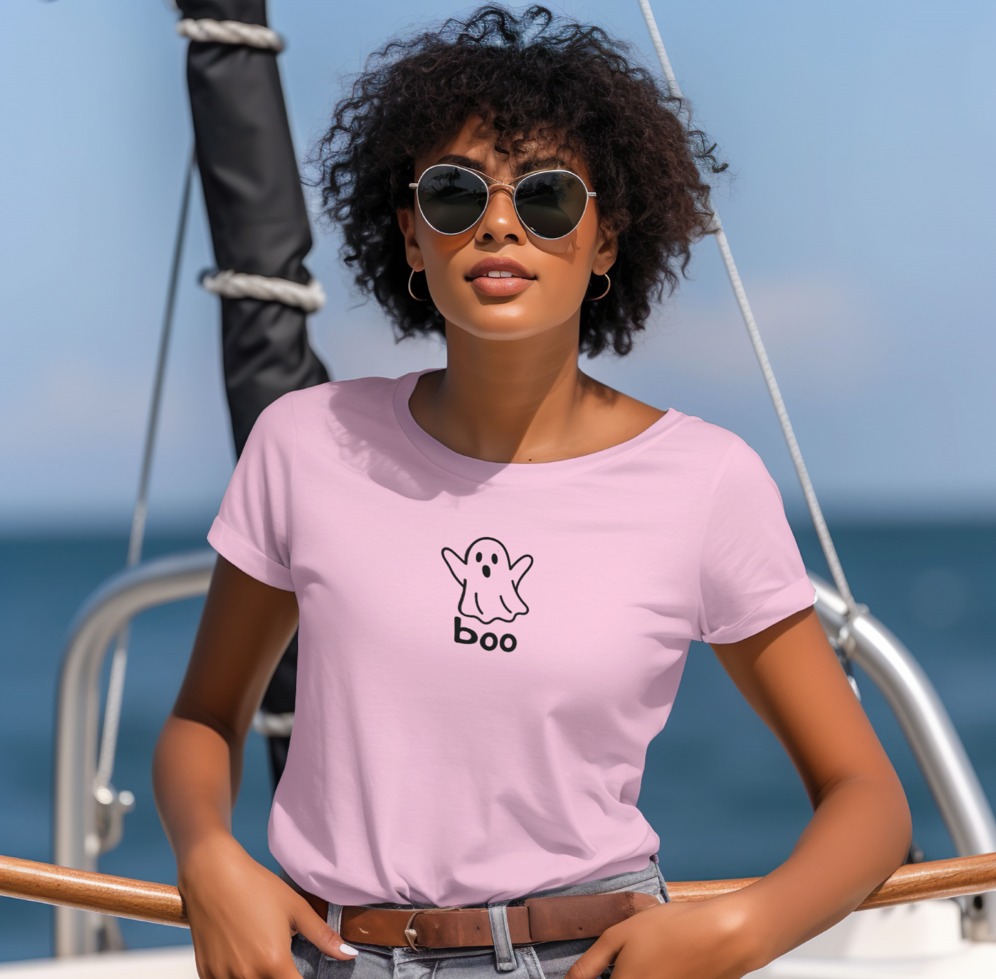 Woman wearing a pink t-shirt with a ghost and 'boo' design on a boat.