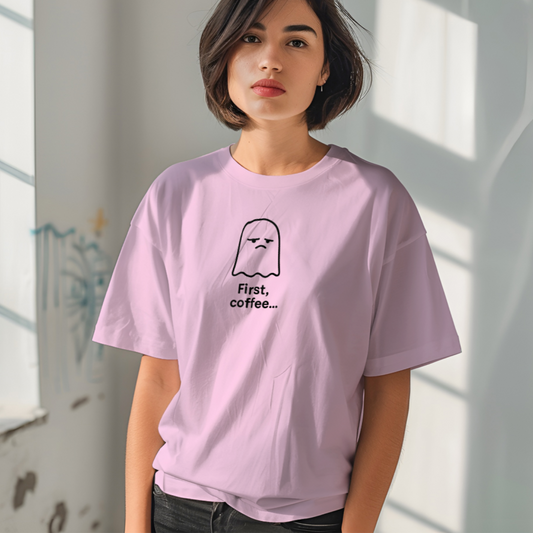 Person wearing a light purple t-shirt with a graphic design in a room with sunlight filtering through.