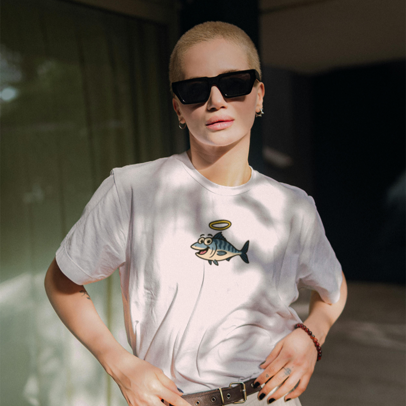Person wearing a white t-shirt with a graphic design, standing outdoors.