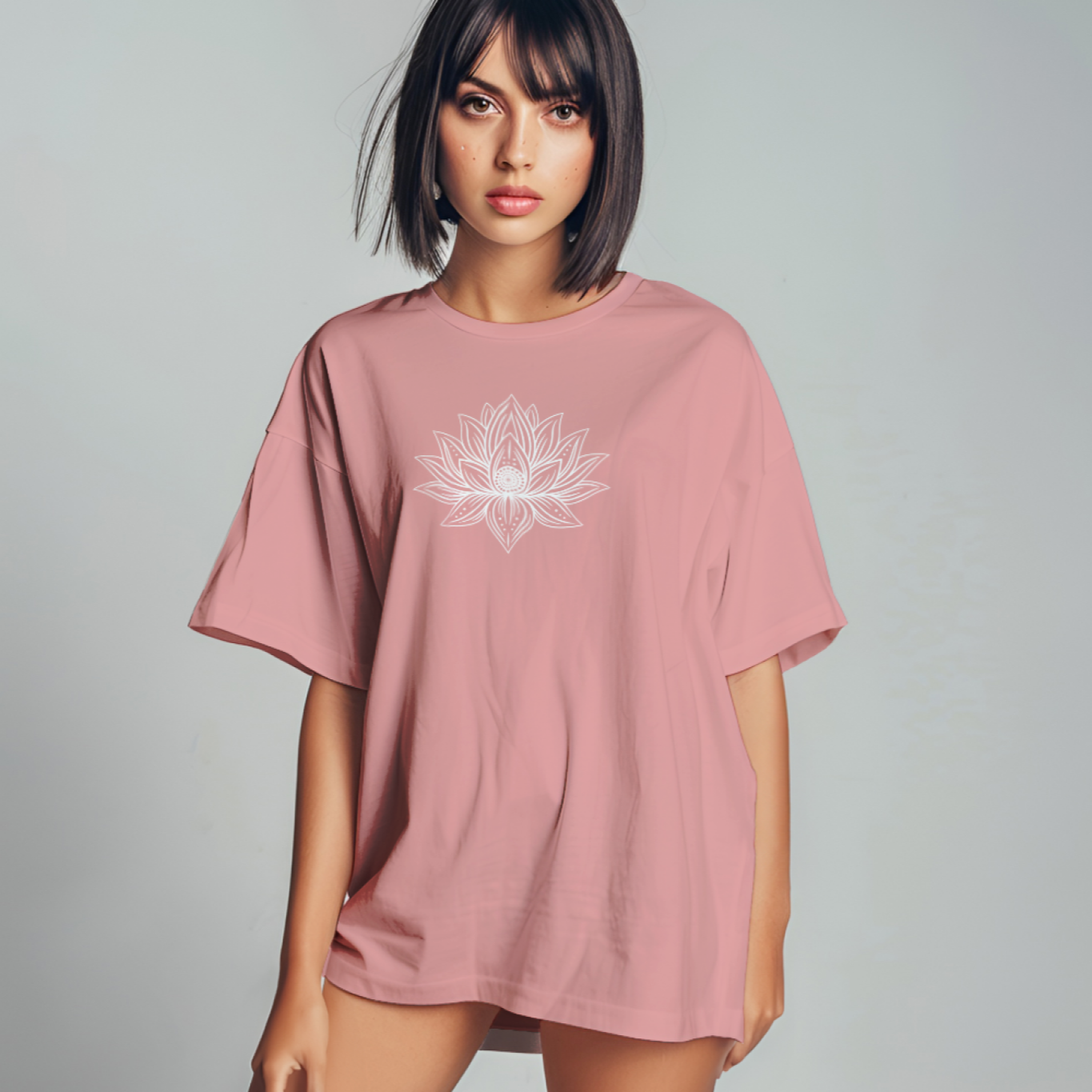 Woman wearing a pink oversized t-shirt with a white graphic on a gray background