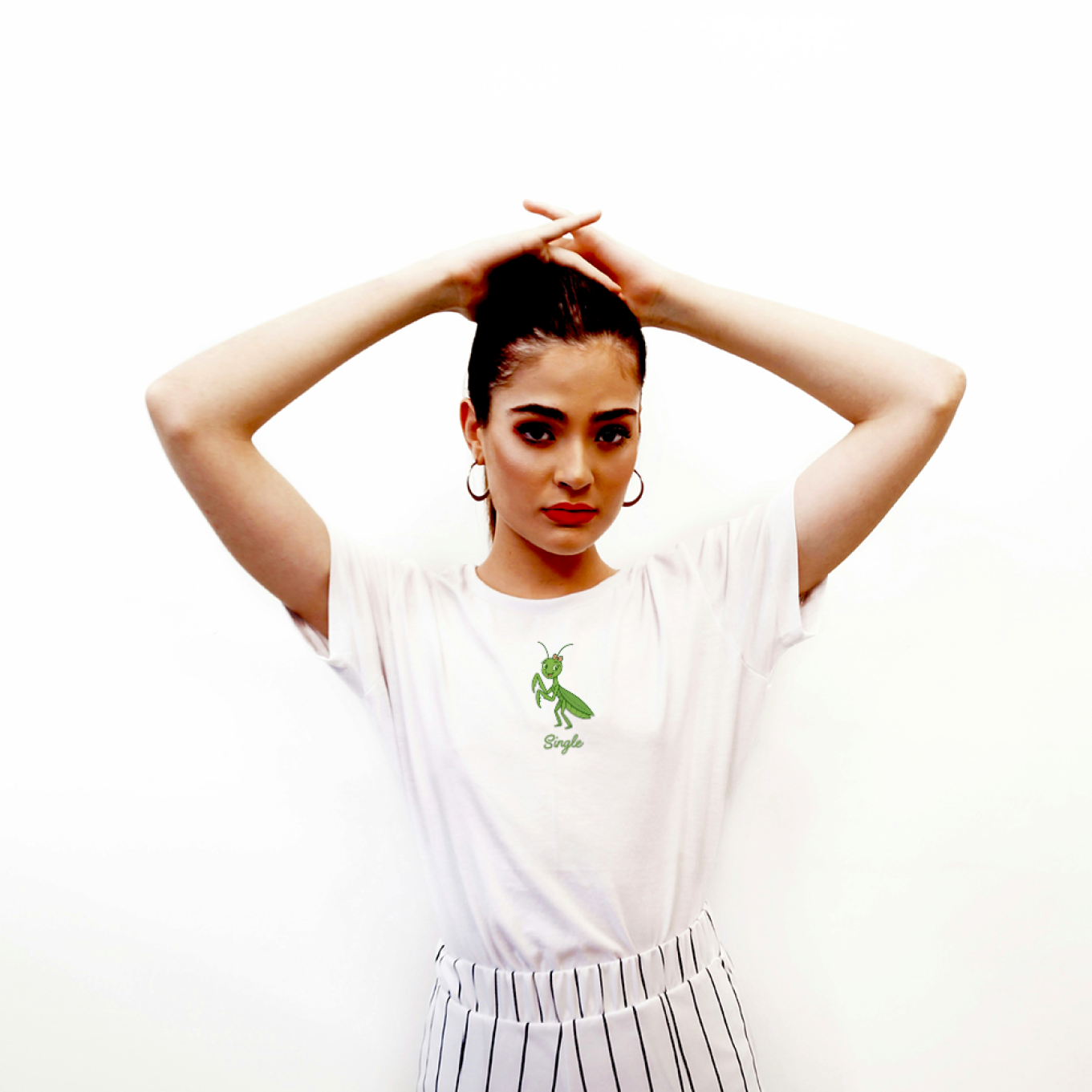 Person wearing a white t-shirt with a green logo and striped pants on a white background