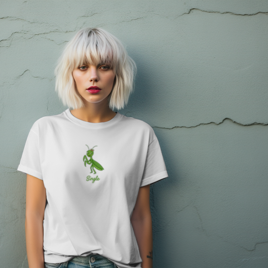 Person wearing a white t-shirt with a green graphic against a textured gray wall