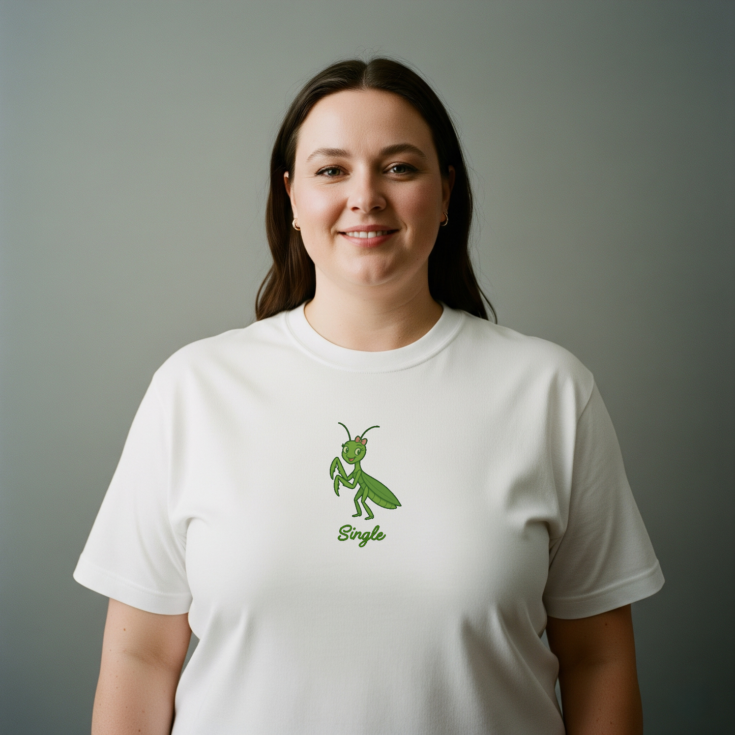 Person wearing a white t-shirt with a green graphic and text on a gray background