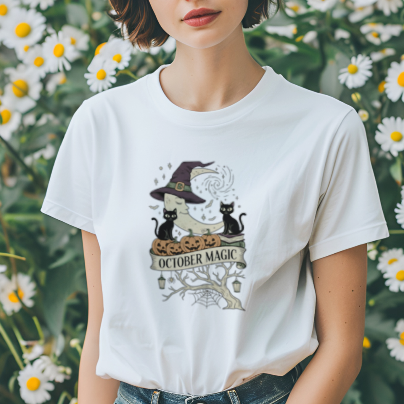 Person wearing a white t-shirt with a graphic design in front of daisies