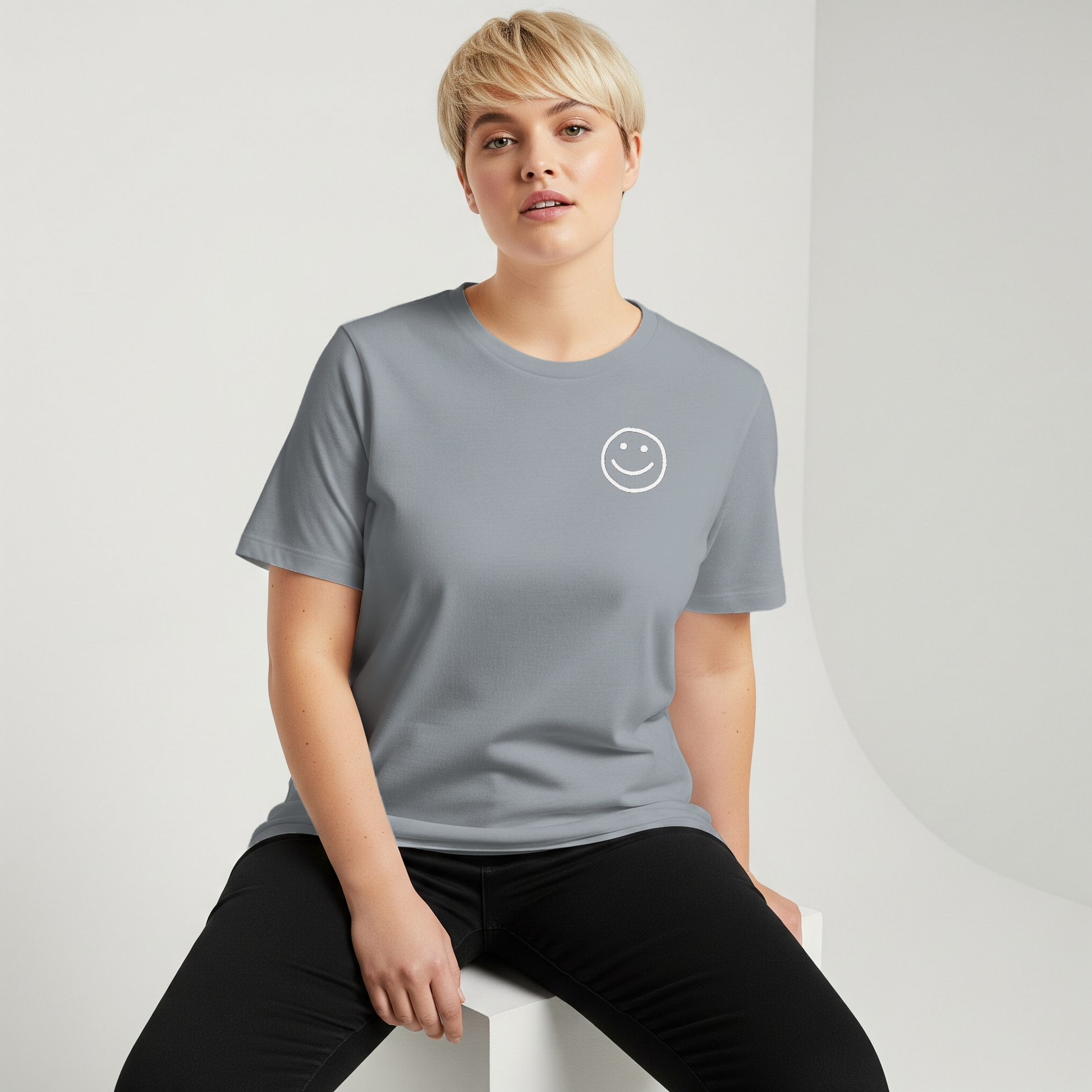Person wearing a gray t-shirt with a smiley face design on a white background