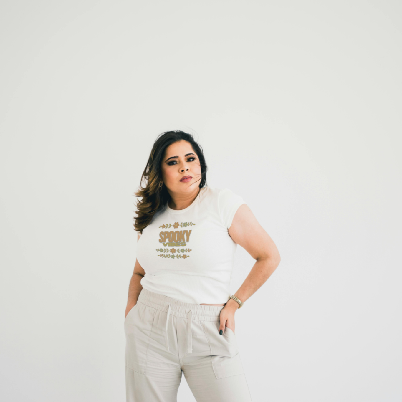 Woman wearing a white t-shirt with text on a plain background