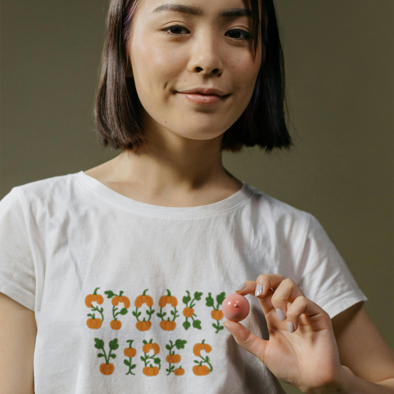 Woman wearing a white t-shirt with a colorful design on a brown background