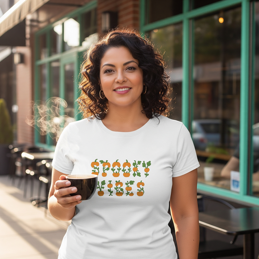 Woman holding a coffee cup wearing a white t-shirt with a graphic design in an urban setting.