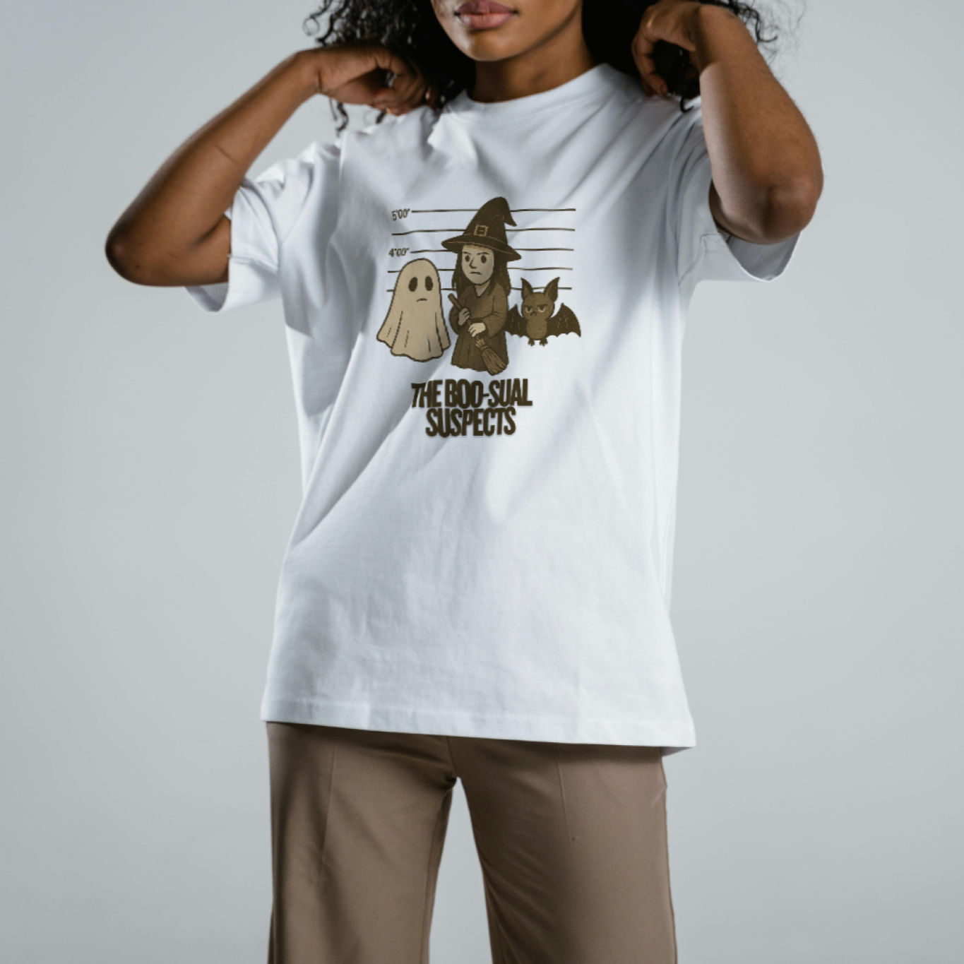 Person wearing a white t-shirt with a graphic design on a plain background