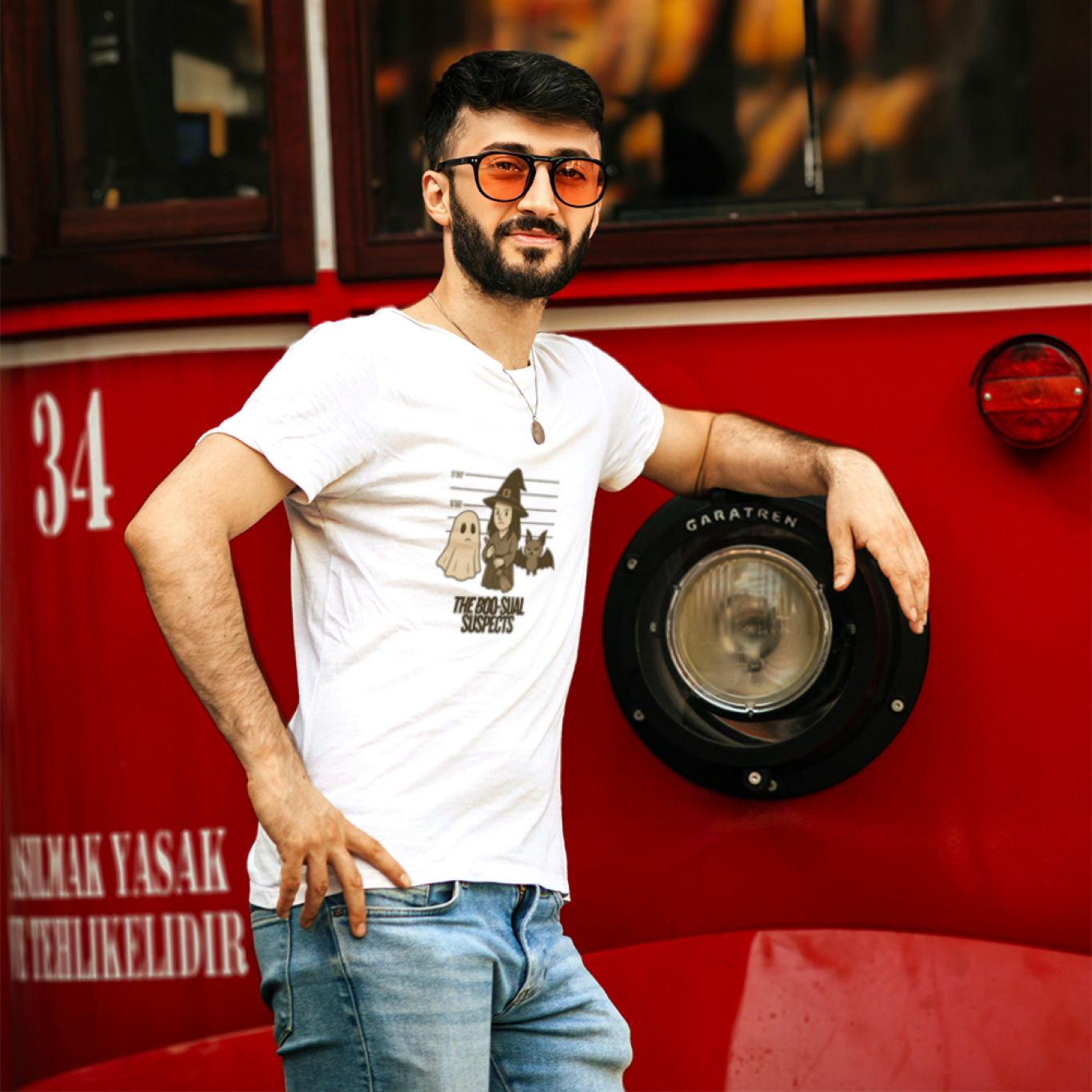 Man leaning against a red bus with a blurred background