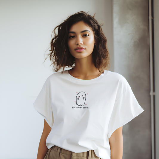 Woman wearing a white t-shirt with a small graphic design on a plain background