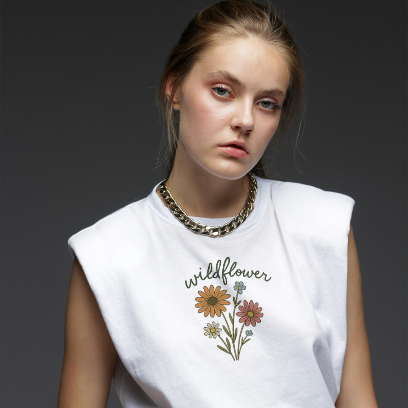 Woman wearing a white sleeveless shirt with floral design and text on a dark background
