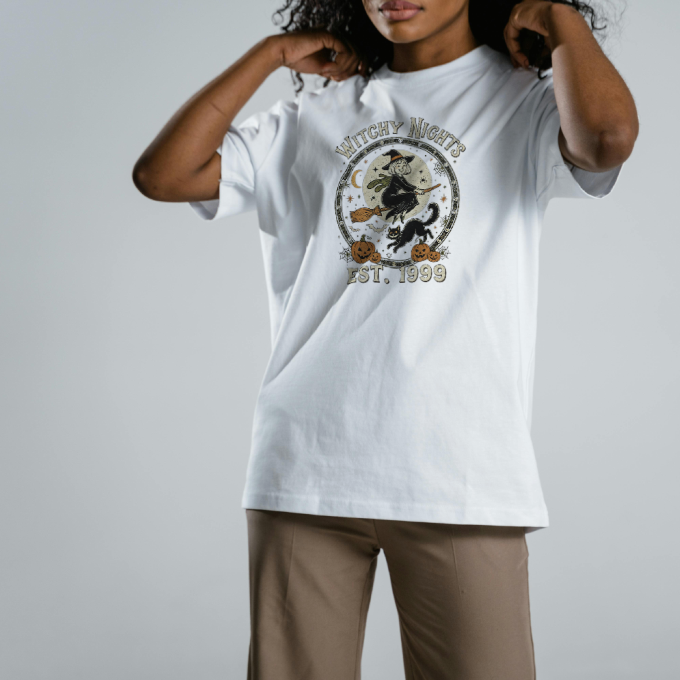 Person wearing a white t-shirt with a graphic design on a plain background